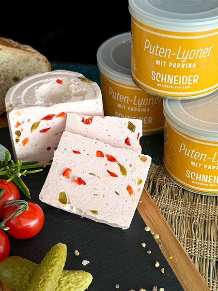 Unsere Puten-Lyoner mit Paprika verbindet fein zerkleinertes Putenfleisch mit einer angenehm milden Würzung und 10% Paprika für Farbe, Frische und einen runden Geschmack. Sie ist saftig, streichzart im Biss und bewusst zurückhaltend gewürzt.