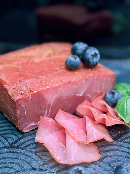 Mageres Rauchfleisch aus regionaler Schweinekeule, trocken gepökelt, monatelang gereift und über Buchenholz geräuchert – intensiv im Geschmack, komplett ohne Fettrand.