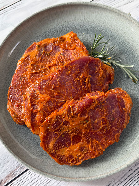 Saftige Schweinehals-Steaks in milder Kräuter-Marinade – perfekt für Grill oder Pfanne.