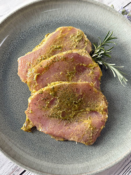 Unsere Kräuterbutter Schweine-Rücken-Steaks verbinden zartes, mageres Schweinefleisch mit einer fein abgestimmten Kräuterbutter-Marinade.