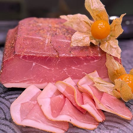 Herzhafter Schinken-Speck aus regionaler Schweinekeule, trocken gepökelt, monatelang gereift und über Buchenholz geräuchert – kräftig im Geschmack mit feiner Würze.